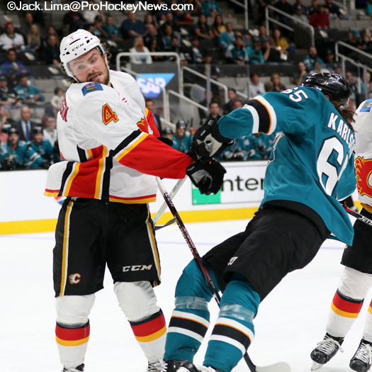 Calgary defenceman Rasmus Andersson (4) checks Erik Karlsson
