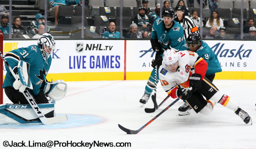 Flames forward Derek Ryan (10) attempts to take a shot on Sharks goalie Martin Jones as Evander Kane (9) defends