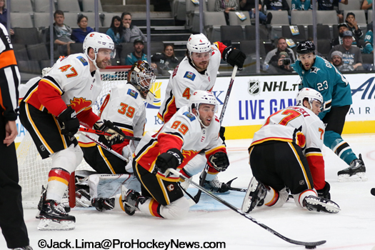 (L-R) Andrew MacDonald (47) - Cam Talbot (39) - Rasmus Andersson (4) - Alan Quine (89) and Mark Jankowski (77) look to control a rebound as Sharks Barclay Goodrow(23) looks on