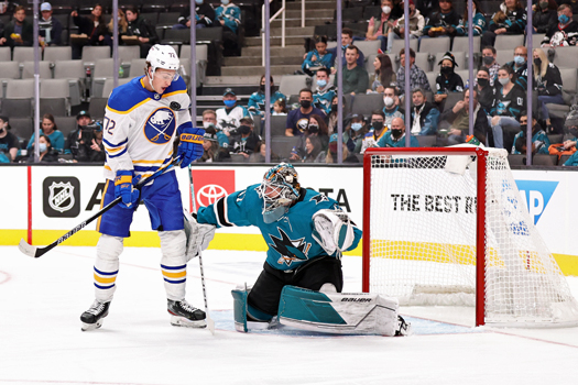 Tage Thompson (72) gets hit in the chest with a shot as he tries to screen Sharks goalie James Reimer