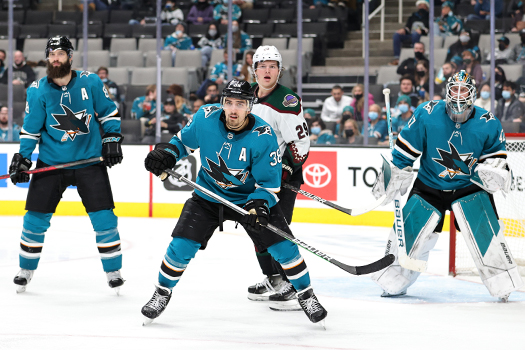 Mario Ferraro (38) positions himself in front of Barrett Hayton (29) and Sharks' goalie James Reimer