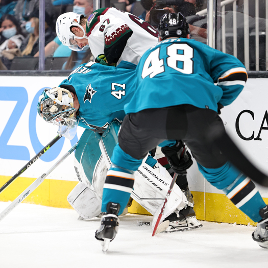 Sharks' goalie James Reimer (47) gets tied up behind the net with Larson Crouse (67)