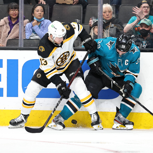 Charlie Coyle (13) and Logan Couture (39) battle for the puck along the boards