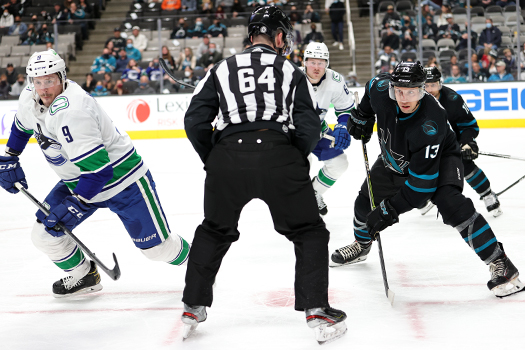 J.T. Miller (9) and Andrew Cogliano (11) look for the puck after a face-off.