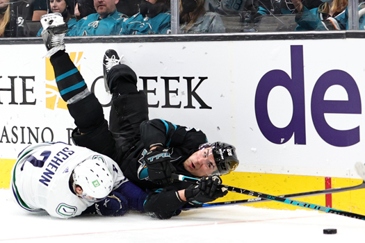 Luke Schenn (2) and Timo Meier (28) battle for the puck along the boards.