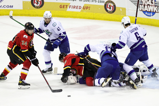 Walker Duehr (34) tries to control a rebound from a scrum in front on the net