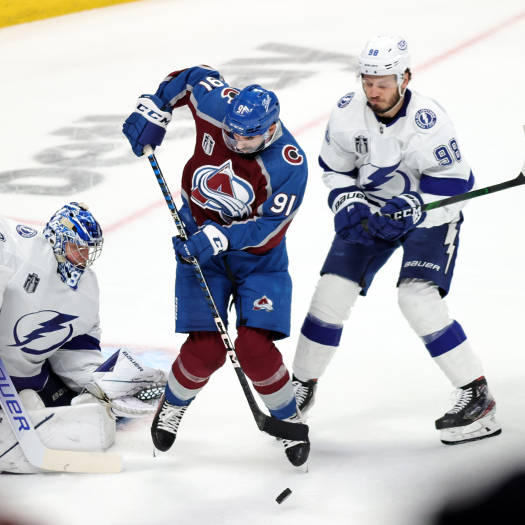 Nazem Kadri (91) tries to tip a shot past goalie Andrei Vasilevskiy as Mikhail Sergachev (98) provides support