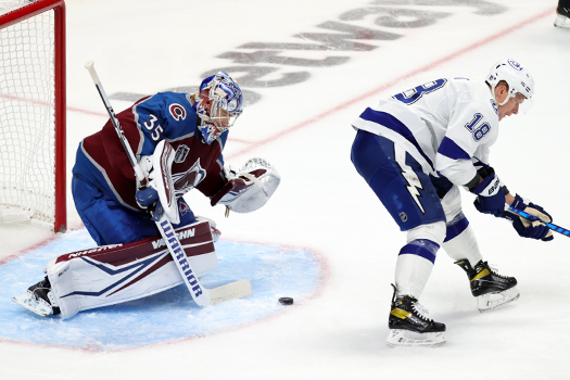 Ondrej Palat (18) tries to tip a shot past Avalanche goalie Darcy Kuemper (35)