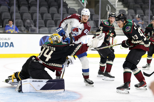 Coyotes goalie Anson Thornton (34) makes a glove save as Danila Zhuravlyov (82) and Keaton Dowhaniuk (93) look for a rebound