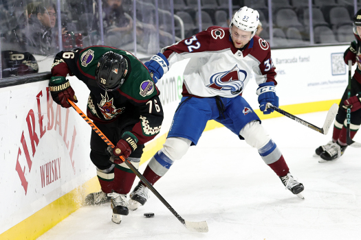 Manix Landry (76) and Nolan Orzeck (32) battle for the puck behind the net
