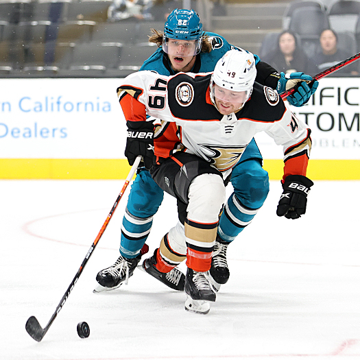 Max Jones (49) moves the puck past Artem Guryev (82)