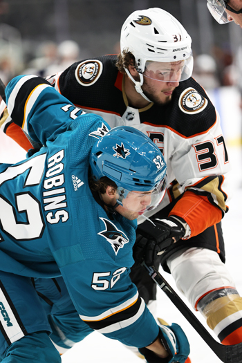 Tristen Robins (52) and Mason McTavish (37) battle during a faceoff