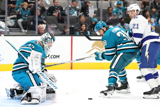 Sharks goalie James Reimer (47) blocks a shot as defenseman Mario Ferraro (38) tries to clear the rebound away from Brayden Point (21)