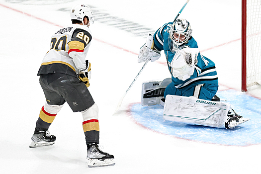 Sharks goalie James Reimer makes a glove save while Chandler Stephenson (20) looks for a rebound