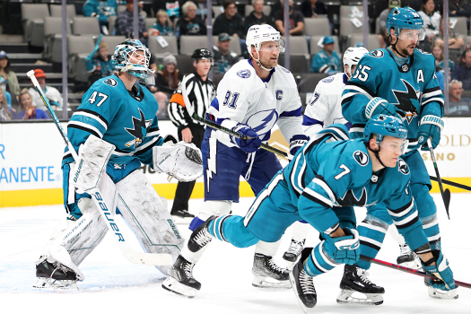 Steven Samkos (91) cross-checks Nico Surm (7) to clear space in front of the net