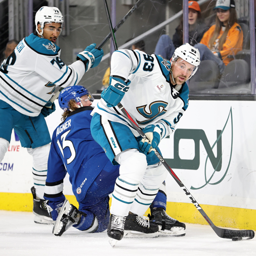 Barracuda's defenseman Patrick Sieloff (93) moves the puck away from Ryan Wagner (13) and teammate Montana Onyebuchi (79)