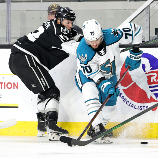 Brandon Coe (70) tries to move the puck away from Tobie Bisson (12)