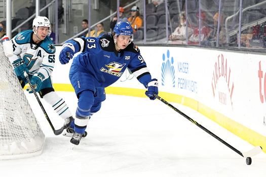 Jean-Luc Foudy (93) reaches for the puck as Derrick Pouliot (55) pursues