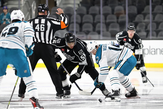 Referee Brandon Schrader (46) drops the puck on the game opening faceoff between Quiton Byfield (55) and Jasper Weatherby (14)