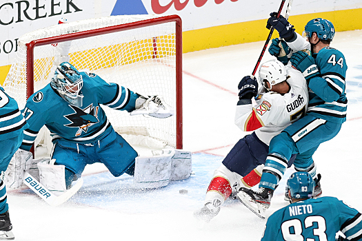 Sharks defenseman Marc-Edouard Vlasic (44) ties up Radko Gudas (7) as goalie James Reimer makes a save