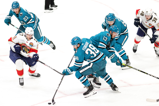 Sharks defenseman Mario Ferraro (38) moves the puck away from Eetu Luostarinen (27)