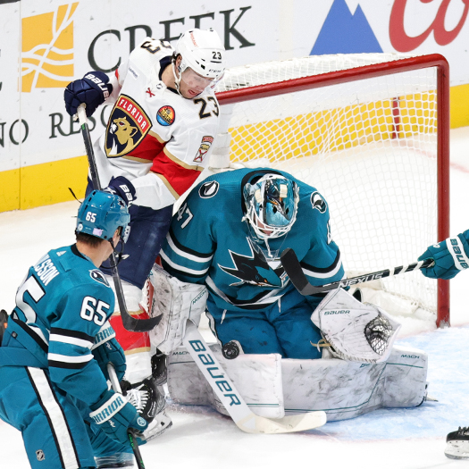 Sharks goalie James Reimer (47) stops a shot as Carter Verhaeghe (23) looks for a rebound