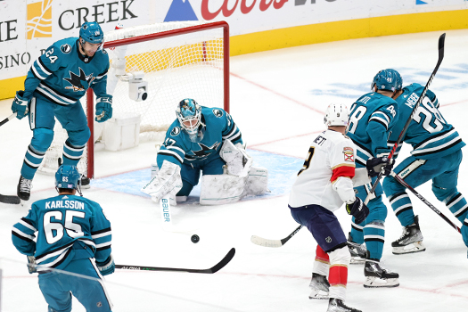 Sharks goalie James Reimer (47) swats away a rebound as defenseman Jaycob Megna (24) looks to help