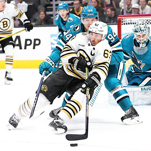 Bruins captain Brad Marchand (63) loses contol of the puck as he turns to attempt to make a pass in front of Sharks forward Alexander Barabanov (94)
