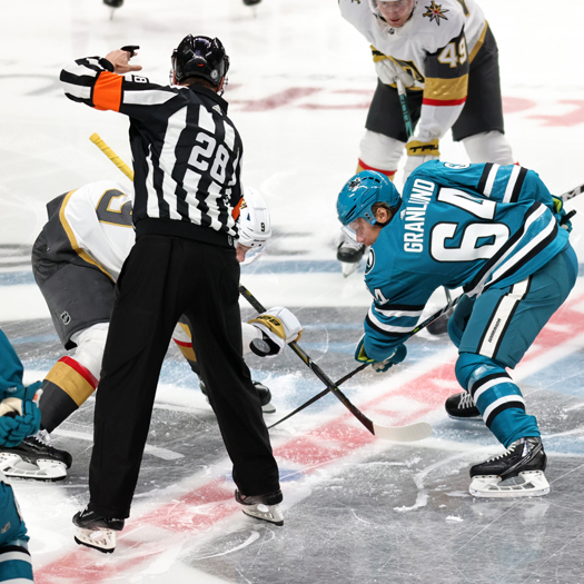 Referee Chris Lee (28) drops the puck on the games opening faceoff between Jack Eichel (Left) and Mikael Granlund (64)