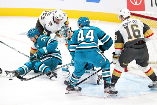 Sharks defenseman Mario Ferraro (38) attempts to contain a loose puck in front of Michael Amadio (22) and Sharks goalie Kaapo Kahkonen