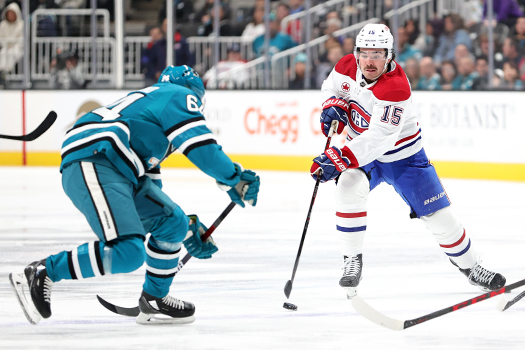 Canadians center Alex Newhook (15) attempts to move the puck past Mikael Granlund (64)