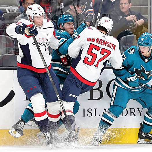 Capitals Aliaksei (21) and Trevor van Riemsdyk (57) check Ty Emberson (6) into the boards as William Eklund (72) looks for the puck