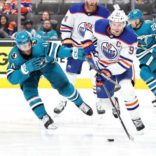 Conor McDavid (97) skates around Luke Kunin (11) during an Oilers third period power play