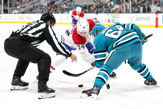 Linesman Kiel Murchison drops the puck on a face-off between Nick Suzuki (14) and Mikael Granlund (64)