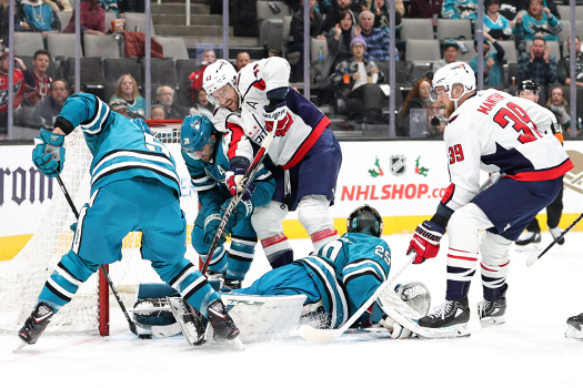 Sharks defenseman Matt Benning (5) moves the puck away from the net after a stop by goalie Mackenzie Blackwood as Capitals Tom Wilson (43) and Hendrix Lapierre (29) look for a rebound