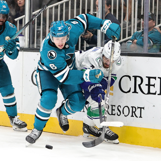 Sharks defenseman Ty Emberson (6) and Conor Garland fight for the puck along the boards