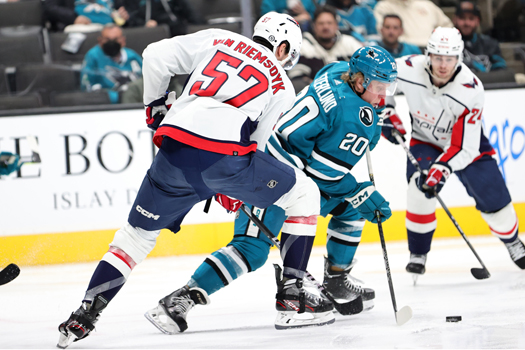 Sharks forward Fabian Zetterlund (20) skates around Trevor van Riemsdyk (57)