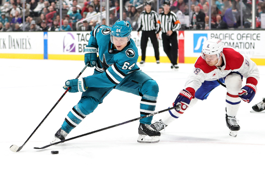 Sharks forward Mikael Granlund (64) attempts to move around defenseman Mike Matheson (8) during overtime action