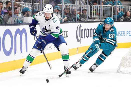 Sharks forward Mike Hoffman (68) applies pressure to Canucks defenseman Quinn Hughes (43)