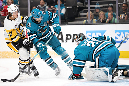 Sharks goalie Mackenzie Blackwood covers the puck in front of Rickard Rakell (67) and Jan Rutta (84)