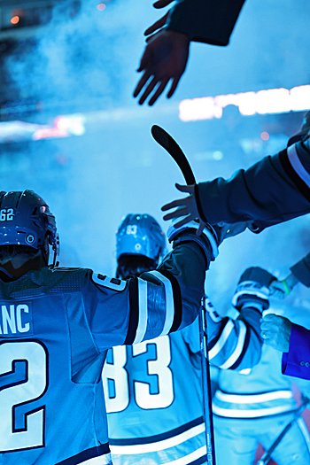 Sharks players Kevin Labanc (62) and Nikita Okhotiuk (83) received high-fives from fans as they enter the ice