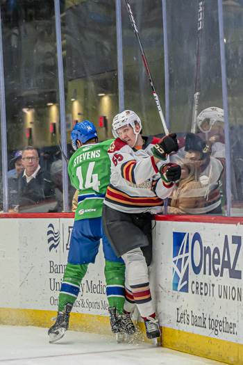 Abbotsford center John Stevens checks Tucson Defenseman Max Szuber into the boards