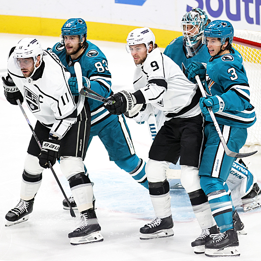 Kings Anze Kopitar (11) and Adrian Kempe (9) attempt to screen Sharks goalie Kaapo Kahkonen as Nikita Okhotiuk (83) and Henry Thrun (3) defend