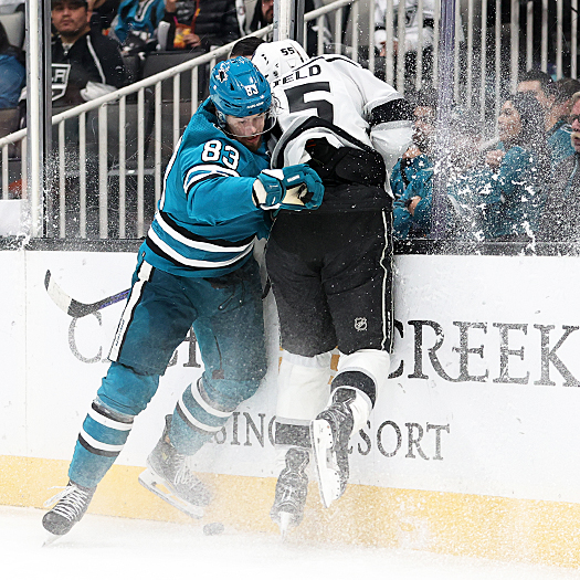 Sharks defenseman Nikita Okhotiuk (83) checks Quinton Byfield (55) into the boards as they fight for the puck
