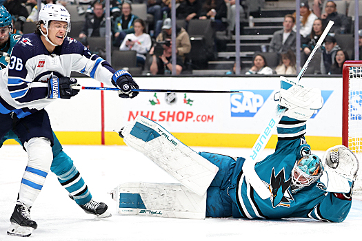 Sharks goalie Mackenzie Blackwood dives to get back in position as Morgan Barron (36) attempts to deflect the puck