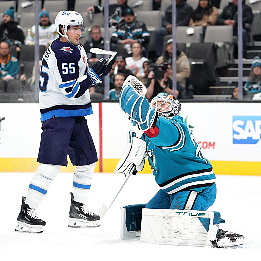 Sharks goalie Mackenzie Blackwood makes a glove save as Jets forward Mark Scheifele (55) attempts to tip the puck