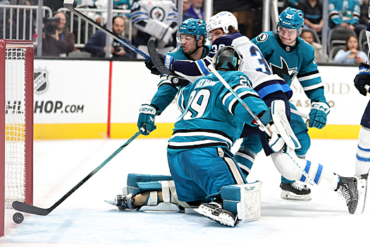 Morgan Barron (36) taps the puck by Sharks goalie Mackenzie Blackwood as defenseman Marc-Edouard Vlassic attempts to swipe the puck away from the goal