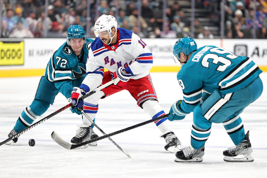 Rangers Forward Vincent Trocheck (16) splits Sharks defenders William Eklund (72) and Logan Couture (39) as he skates up ice