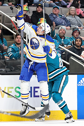 Sabres center Tage Thompson (72) reaches up for a loose puck in front of Sharks Tomas Hertl