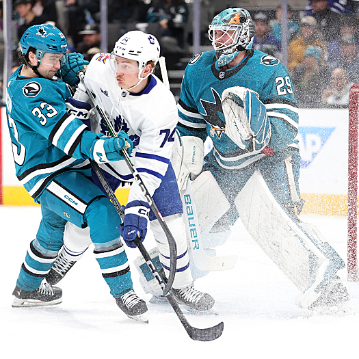 Sharks defenseman Calen Addison (33) attempts to move Bobby McMann (74) out of the goal crease in front of Sharks goalie Mackenzie Blackwood